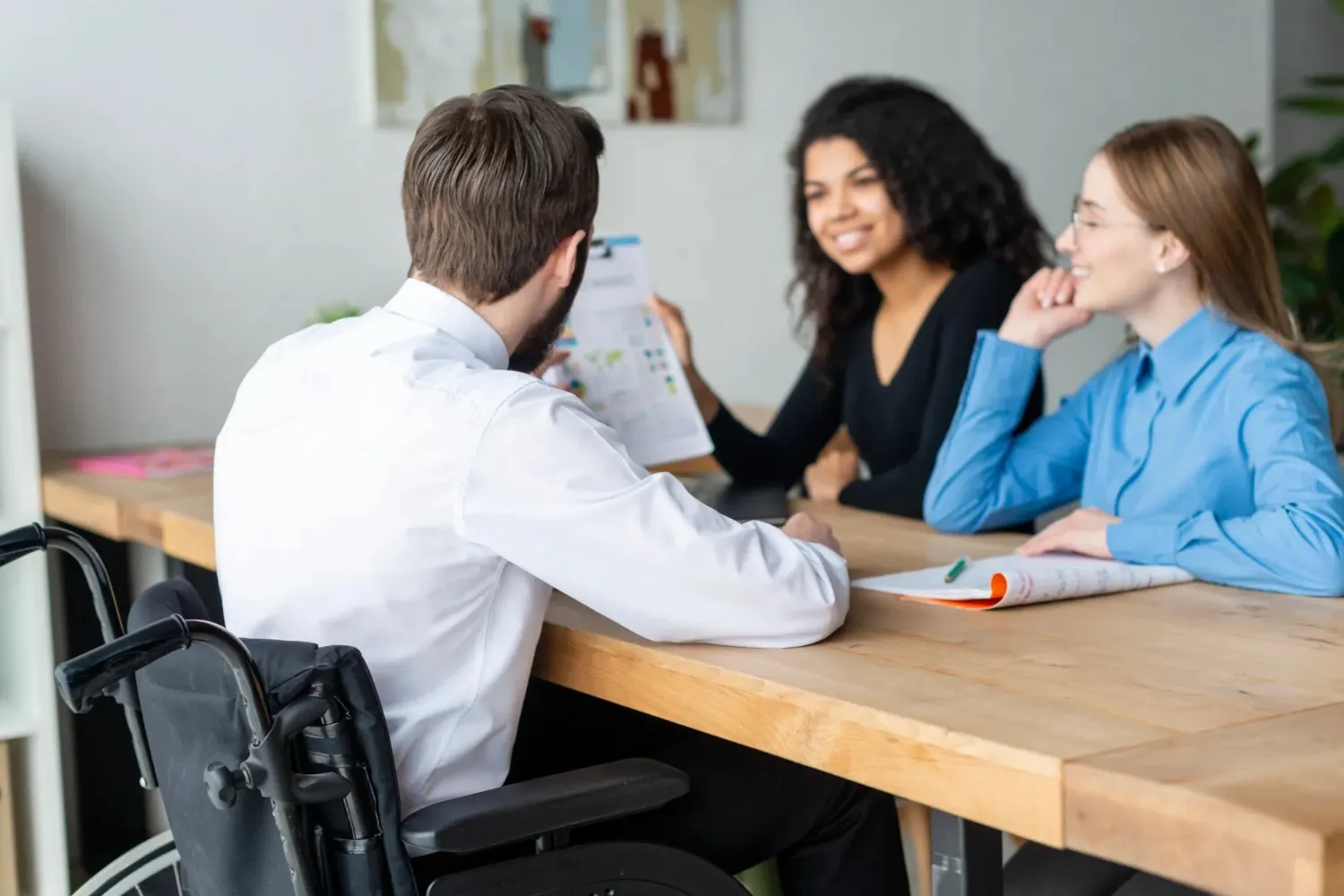 Healthcare professional in a wheelchair discussing during a behavioral health consultation