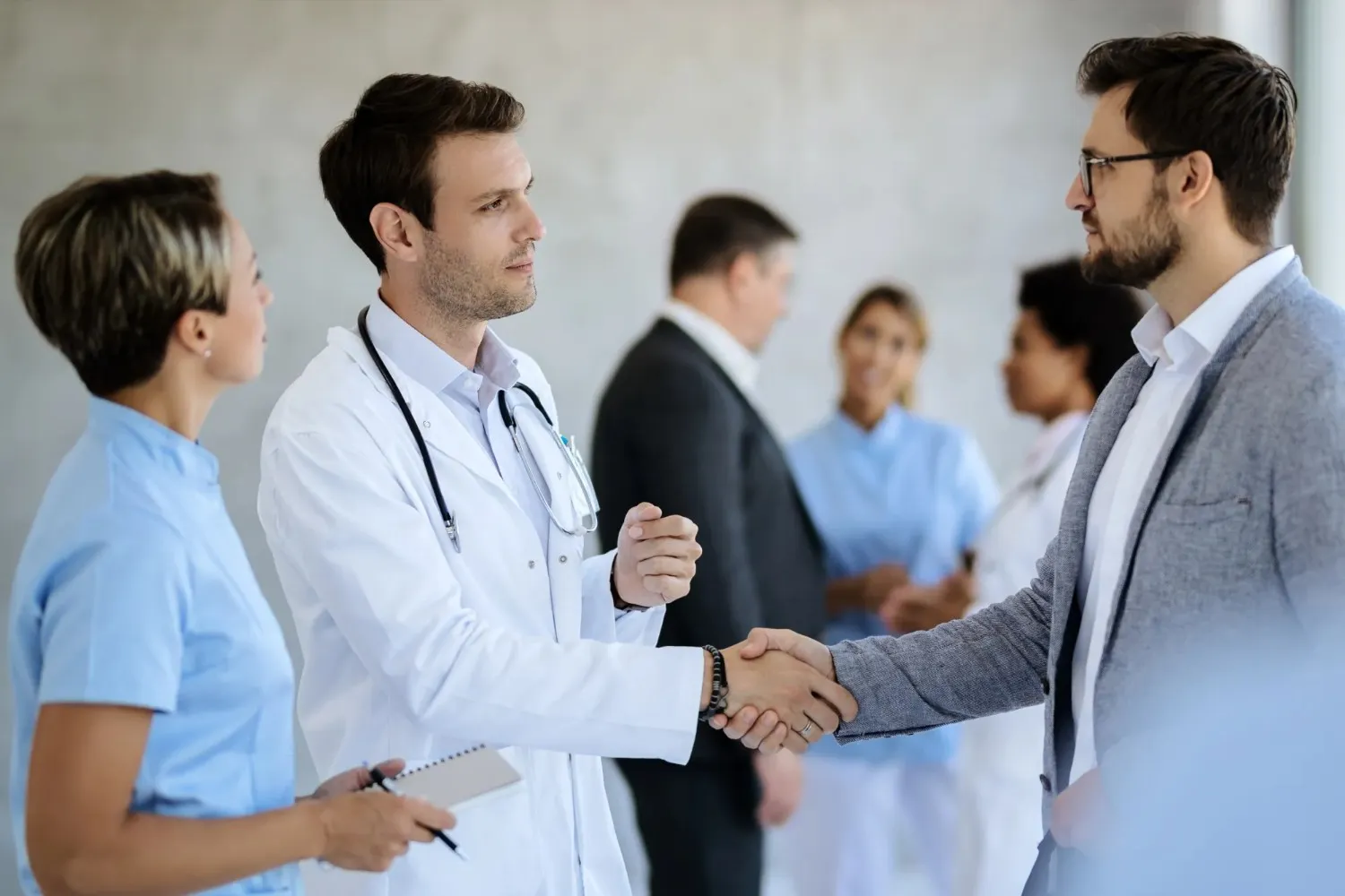 A male doctor in a white lab coat during successful professional care coordination referral.