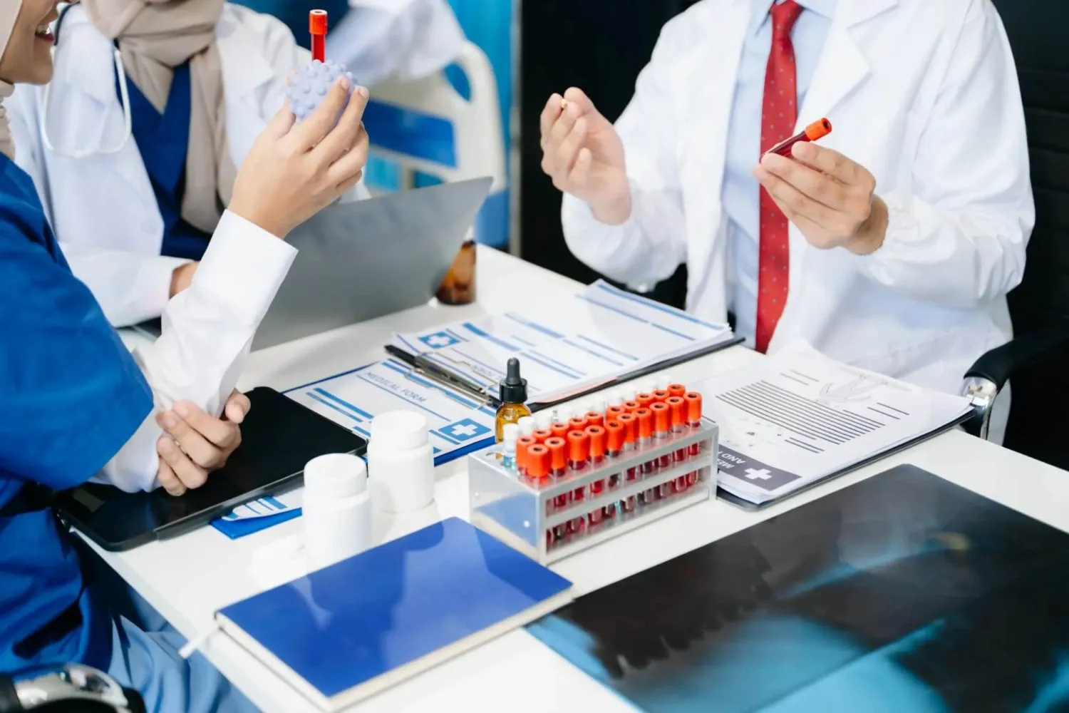 Medical professionals in a lab setting analyzing blood samples and diagnostic test results