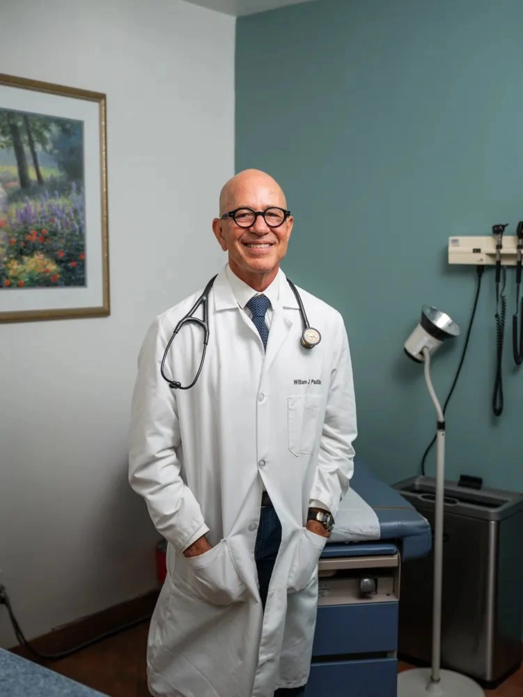 Dr. William Padilla using a stethoscope to check a patient's vitals during a check-up.